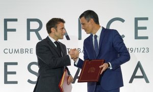 El presidente de Francia, Emmanuel Macron (i) y el presidente del Gobierno, Pedro Sánchez (d), se dan la mano tras la firma de un Tratado de Amistad entre sus respectivos países.