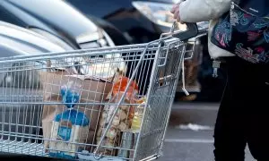 Una mujer sale de un supermercado con un carro de la compra, a 27 de diciembre de 2022, en Mejorada del Campo, Madrid.