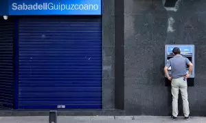 Un cliente opera en un cajero automático de una oficina del  Banco Sabadell en Guernica. REUTERS/Vincent West