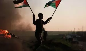 Un manifestante con la bandera de Palestina en la frontera de Gaza protesta tras los últimos ataques contra un campamento de refugiados en Yenín.