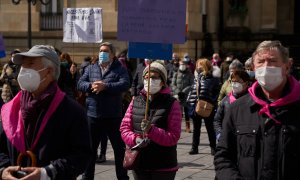 Varias personas con carteles en una manifestación en homenaje a los residentes fallecidos por coronavirus en la Plaza de la Diputación de Vitoria, País Vasco (España), a 20 de marzo de 2021.