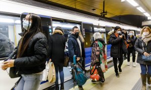 Varias personas bajan y suben de un metro en el andén de la estación de Metro de Callao, a 26 de enero de 2023, en Madrid (España).
