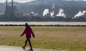 Una mujer pasea junto a la fábrica de la papelera Ence en Pontevedra. EFE/Salvador Sas