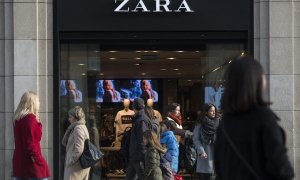 Varios transeúntes pasan por delante de una tienda de Zara anunciando descuentos en el primer día de las rebajas de invierno en Barcelona. el 7 de enero de 2017.