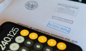 Una calculadora y una escritura de compraventa de una hipoteca, a 2 de junio de 2022, en Madrid.