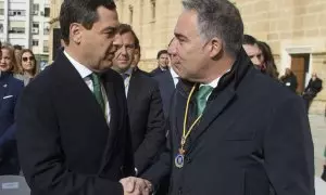 El presidente de la Junta de Andalucía, Juanma Moreno (i), saluda al coordinador general del PP, Elías Bendodo, a su llegada al acto institucional con motivo del Día de Andalucía celebrado este martes