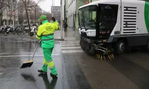 Un treballador netejant a la superilla del Poblenou de Barcelona, juntament amb una de les màquines de la nova flota de vehicles.