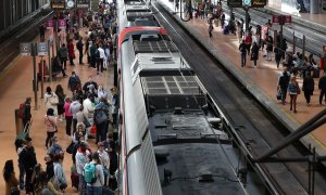 Numerosas personas con maletas esperan en el andén la salida de un tren, en la estación Almudena Grandes-Atocha, en Madrid, a 31 de marzo de 2023.