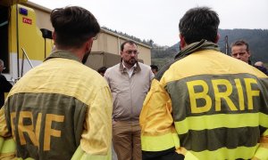 El presidente del Gobierno de Asturias, Adrián Barbón, con dos bomberos de la Unidad Militar de Emergencias (UME), que trabajan en las labores de extinción del incendio, en el puesto de mando avanzado de Navelgas, a 30 de marzo de 2023, en Navelgas, Tineo