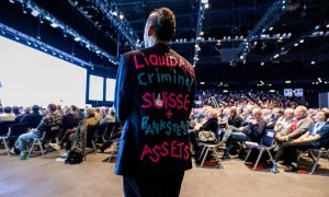 Un accionista descontento lleva un blazer con un texto en la espalda durante la reunión general anual de Credit Suisse, dos semanas después de ser comprado por su rival UBS en un rescate negociado por el gobierno, en Hallenstadion, Zúrich, Suiza, el 4 de