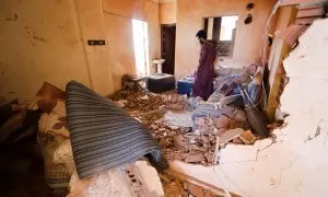 Un hombre busca entre sus pertenencias en una vivienda afectada por los combates en Jartum, a 17 de abril de 2023.