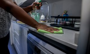 Una mujer aplica un producto de limpieza en la encimera de la cocina. Imagen de Archivo.