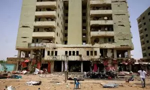 27/04/2023 Un hombre camina entre los restos de un coche y del mercado central de Jartum, en pleno conflicto en Sudán