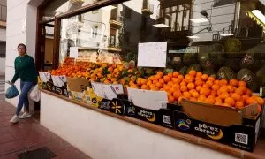 Una mujer sal de comprar en una frutería en la localidad malagueña de Ronda. REUTERS/Jon Nazca