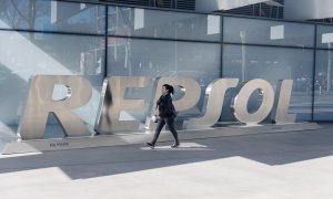 Una mujer camina frente a las letras Repsol en su sede en Madrid. E.P./Eduardo Parra
