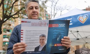 El candidat del PP a l'alcaldia de Badalona, Xavier García Albiol, llegeix el manual d'actuació contra les ocupacions il·legals.