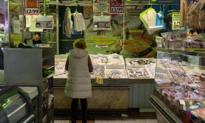 Una mujer compra en una pescadería en un mercado, a 15 de marzo de 2023, en Madrid.