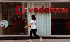 Una mujer pasa por delante de una tienda de Vodafone en Ronda (Málaga). REUTERS/Jon Nazca
