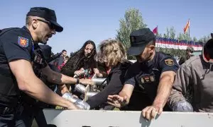 Activistas de Desarma Madrid forcejean con la Policía durante una protesta contra la celebración de la Feira Internacional de Seguridad y Defensa en Madrid.
