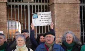 Una mujer levanta una pancarta de 'Stop desahucios' durante una concentración de la Plataforma de Afectados por la Hipoteca (PAH) .