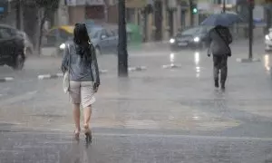 Dos personas pasean bajo la lluvia durante la tarde de este martes 23 de mayo de 2023 en València.