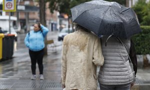 23/05/2023 - Una pareja se resguarda de las lluvias de este martes, que continuarán durante el resto de la semana especialmente en el este del país.