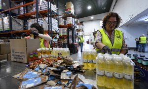 Un par de mujeres organizan los productos que se repartirán en el Banc dels Aliments de Barcelona