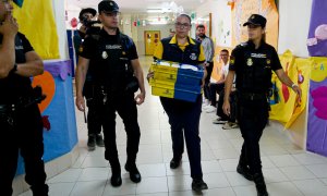 Dispositivo de Seguridad en Colegio León Solá de Melilla en el que varios agentes escoltan a la funcionaria de Correos a la mesa electoral para entregar los votos por correo.