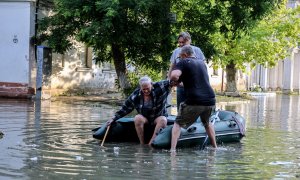 06/06/2023 - Dos personas ayudan a un anciano a subirse a un bote inflable mientras evacua de su casa en una calle inundada de Kherson, Ucrania, a 6 de junio de 2023.