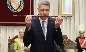 L'alcalde de Badalona, Xavier García Albiol, mira a càmera mentre petoneja la vara d'Alcaldia un cop investit per tercer cop batlle de la ciutat.