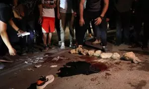 Varias personas se reúnen frente a un charco de sangre en el lugar donde dos palestinos resultaron heridos a causa de los enfrentamientos, a 19 de junio de 2023.