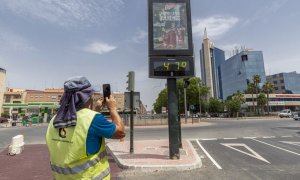Un hombre fotografía un termómetro que marca 47 grados este miércoles en Murcia