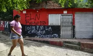 Una mujer pasa frente a una casa con un grafiti de la guerrilla del ELN cerca de Cacuta, Colombia, a 4 de julio.