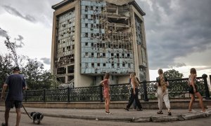 Varias personas pasan frente a un edificio destruido en un ataque ruso con drones en Izmail, en la región ucraniana de Odesa, a 2 de agosto de 2023