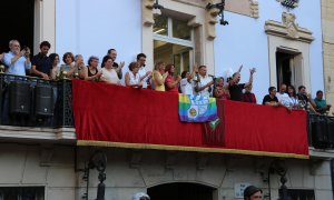La capitana de l’equip femení de futbol del Club Esportiu Europa, Andrea Porta, i el capità de l’equip masculí, Àlex Cano, amb autoritats municipals al balcó de la seu de la Vila de Gràcia.