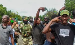 La gente posa con soldados mientras celebran en apoyo a los golpistas en una calle de Libreville, Gabón.