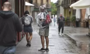 Varias personas caminan bajo la lluvia, a 2 de septiembre de 2023, en Huesca, Aragón (España).