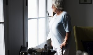 Una mujer mayor mira por una ventana (Archivo)