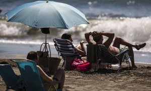 Numerosas personas disfrutan del buen tiempo y sol el domingo en la playa del Rincón de la Victoria (Málaga).