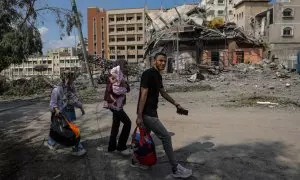 Una familia palestina carga con sus pertenencias en el destrozado barrio de Al-Ramal, en Gaza, tras la ofensiva de Israel este 10 de octubre de 2023.