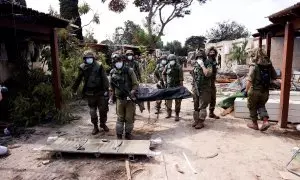 Soldados israelíes llevan el cuerpo de una de las víctimas del ataque de milicianos de Hamás al Kibbutz Kfar Aza, en el sur de Israel. REUTERS/Ronen Zvulun