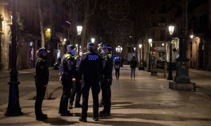 Agentes de la Guardia Urbana informan a los viandantes de la entrada en vigor del toque de queda en Barcelona, en diciembre de 2021. Archivo / Europa Press