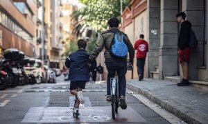 Dos nens es mouen en bici i patinet per Barcelona - Jordi Borràs/ACN