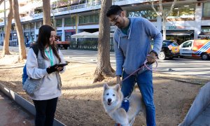 Una informadora municipal explica les zones d’ús compartit a un veí que passeja el gos, a l’avinguda de Josep Tarradellas de Barcelona