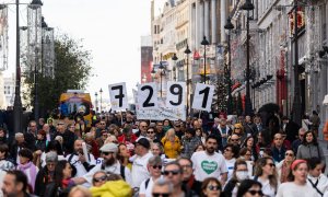 Varias personas llevan carteles que indican el número de fallecidos en residencias en la pandemia, durante una manifestación convocada por Marea de Residencias, en Madrid, a 26/11/2023