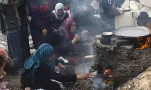 Familias palestinas desplazadas hacen pan en un horno de leña debido a la ausencia de gas en un campo de refugiados en Rafah, en las Franja de Gaza, este sábado. El número de víctimas en la Franja de Gaza subió a 20.258 muertos y 53.688 heridos desde que