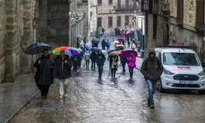 Varias personas caminan bajo la lluvia en Toledo, a 3 de enero de 2024.
