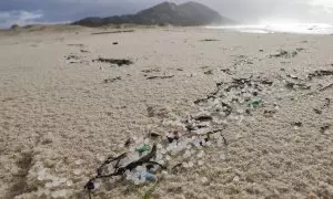 Miles de bolitas de pellets para la fabricación de plásticos, procedentes de un contenedor que cayó al mar desde un barco, esta mañana en la playa de Area Maior.