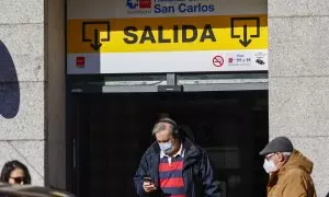08/01/24 - Personas con mascarillas en la salida de un hospitalen Madrid este lunes, día en el que el Ministerio de Sanidad ha pedido a las comunidades que implanten el uso obligatorio de la mascarilla en centros sanitarios y sociosanitarios,