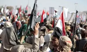 Varias personas sostienen armas y ondean banderas palestinas durante una protesta tras los ataques aéreos de Estados Unidos y el Reino Unido contra instalaciones militares hutíes, en Yemen, a 12/1/2024
